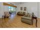 Open concept living room featuring laminate floors, neutral walls, comfortable sofas, and a sliding glass door at 1531 Belfry Dr, Venice, FL 34292