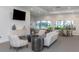 Comfortable lounge area with modern furnishings, large windows, and a mounted television at 1531 Belfry Dr, Venice, FL 34292