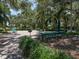 Scenic picnic area with tables, benches, and a grill surrounded by lush greenery and mature trees at 1531 Belfry Dr, Venice, FL 34292