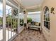 Enclosed porch with decorative tile flooring, iron bench seating, and serene outdoor views at 1531 Belfry Dr, Venice, FL 34292