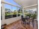 Charming sunroom featuring tile flooring, ample natural light, and serene outdoor views at 1531 Belfry Dr, Venice, FL 34292