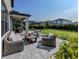 Patio and manicured lawn with stylish wicker furniture, perfect for outdoor living at 15364 Isla Palma Ln, Nokomis, FL 34275