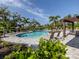 Beautiful community pool with lounge chairs, a pergola, and lush greenery at 15364 Isla Palma Ln, Nokomis, FL 34275