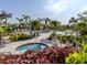 Relaxing community pool area with palm trees, lounge chairs, and a covered seating area at 15364 Isla Palma Ln, Nokomis, FL 34275