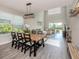 Open-concept dining area with large windows, modern lighting fixture and tile floors overlooking the living room at 15364 Isla Palma Ln, Nokomis, FL 34275