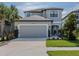 Two-story home featuring a well manicured lawn, a two-car garage, and a gray color scheme at 15364 Isla Palma Ln, Nokomis, FL 34275
