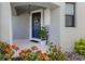 Inviting front entrance featuring a dark blue door with a wreath, potted plants, and vibrant red flowers at 15364 Isla Palma Ln, Nokomis, FL 34275