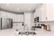 Well-lit kitchen with white cabinets, stainless steel appliances, and modern fixtures and a peninsula at 15364 Isla Palma Ln, Nokomis, FL 34275
