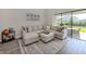 Bright living room featuring a large sectional sofa, decorative rug, and sliding glass doors to outdoor area at 15364 Isla Palma Ln, Nokomis, FL 34275