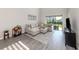 Sunlit living room with large sectional sofa, tile floors and sliding glass doors leading to the backyard at 15364 Isla Palma Ln, Nokomis, FL 34275