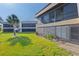 Condo rear exterior showcasing an enclosed lanai with screen windows and manicured lawn at 1728 S Lakeside Dr # 1720B, Venice, FL 34293
