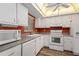 Bright kitchen featuring white appliances, tile ceiling and wood-look floors at 1728 S Lakeside Dr # 1720B, Venice, FL 34293