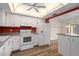 Well-lit kitchen with white cabinets and appliances, accented by wood-look flooring at 1728 S Lakeside Ct # 1720B, Venice, FL 34293