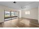 Bright living room featuring wood-look floors, a ceiling fan, and sliding glass doors to a lanai at 1728 S Lakeside Dr # 1720B, Venice, FL 34293