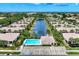 Aerial view of the community, showcasing the pool, clubhouse, pond, and surrounding lush landscape at 1799 Fountain View Cir, Venice, FL 34292