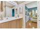 Traditional bathroom features a double sink vanity, neutral color palette, and access to main bedroom at 1799 Fountain View Cir, Venice, FL 34292