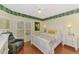 Comfortable bedroom featuring white wooden furniture, hardwood flooring, and bright natural light at 1799 Fountain View Cir, Venice, FL 34292