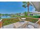 Outdoor deck featuring lounge chairs with a serene view of the lake and lush landscaping at 1799 Fountain View Cir, Venice, FL 34292