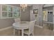 Bright dining area featuring a white table set, chandelier, plantation shutters, and neutral wall color at 1799 Fountain View Cir, Venice, FL 34292