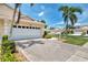 Large driveway leading to a two-car garage with mature landscaping and a walkway at 1799 Fountain View Cir, Venice, FL 34292