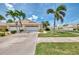 Inviting one-story home with a two-car garage, driveway, and manicured lawn with palm trees at 1799 Fountain View Cir, Venice, FL 34292