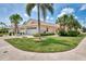 Charming single-story home featuring a two-car garage, lush lawn, and mature palm trees at 1799 Fountain View Cir, Venice, FL 34292