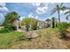 Landscaped exterior view showcasing the home, lawn, and well-maintained yard with palm trees at 1799 Fountain View Cir, Venice, FL 34292