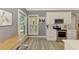 Bright kitchen featuring stainless steel appliances, white cabinetry, light counter tops, and hardwood floors at 1799 Fountain View Cir, Venice, FL 34292