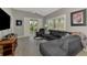 Comfortable living room with a large sectional sofa, ceiling fan, shutters, and a view to the outside at 1799 Fountain View Cir, Venice, FL 34292
