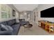 Open-concept living room with sectional sofa, hardwood floors, plantation shutters, adjoins the dining room and kitchen at 1799 Fountain View Cir, Venice, FL 34292