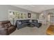Comfortable living room with a sectional sofa, hardwood floors, plantation shutters, and adjoins the dining room at 1799 Fountain View Cir, Venice, FL 34292