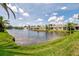 Scenic view of the community lake with fountain, surrounded by well-maintained homes and lush landscaping at 1799 Fountain View Cir, Venice, FL 34292