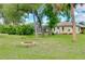 Expansive backyard featuring a fire pit, mature trees, and screened-in lanai for outdoor relaxation at 18375 Lamont Ave, Port Charlotte, FL 33948