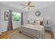 Well-lit bedroom featuring a ceiling fan, natural light and decorative wall mirror at 18375 Lamont Ave, Port Charlotte, FL 33948
