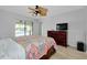 Cozy bedroom with backyard pool access, modern ceiling fan, dresser, and TV at 18375 Lamont Ave, Port Charlotte, FL 33948
