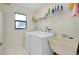 A convenient laundry room equipped with modern washer, dryer, and utility sink at 18375 Lamont Ave, Port Charlotte, FL 33948