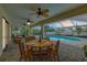 Outdoor dining area with seating for four, featuring a serene view of the pool at 18375 Lamont Ave, Port Charlotte, FL 33948