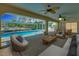 An outdoor living area features a covered pool and patio furnishings with a tropical view at 18375 Lamont Ave, Port Charlotte, FL 33948
