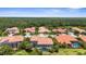 An aerial view showcasing the neighborhood's tile roofs, landscaping, and private screened-in swimming pools at 186 Portofino Dr, Nokomis, FL 34275
