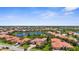 Panoramic aerial view of a beautiful residential area featuring a lake and tiled roof homes amid lush greenery at 186 Portofino Dr, Nokomis, FL 34275