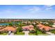 Expansive aerial view of a residential community, showcasing tile roofs, lush landscaping, and serene waterfront properties at 186 Portofino Dr, Nokomis, FL 34275
