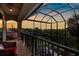 A cozy outdoor balcony with comfortable seating and a beautiful view of the surrounding landscape at sunset at 186 Portofino Dr, Nokomis, FL 34275