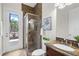 Stylish bathroom featuring a glass-enclosed shower, granite countertop, and access to an outdoor patio at 186 Portofino Dr, Nokomis, FL 34275