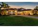 Stunning home exterior at twilight with a brick driveway, manicured lawn, and illuminated architectural details at 186 Portofino Dr, Nokomis, FL 34275