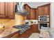 Gourmet kitchen boasts stainless appliances, stylish range hood, and custom cabinetry with tile backsplash at 186 Portofino Dr, Nokomis, FL 34275
