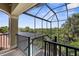 Spacious screened lanai with metal railing, offering views of lush greenery and a peek at the pool at 186 Portofino Dr, Nokomis, FL 34275