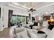 Bright living room featuring stylish sectional sofa, decorative ceiling fan, and sliding glass doors to outdoor space at 186 Portofino Dr, Nokomis, FL 34275