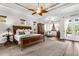 Spacious main bedroom features a tray ceiling, hardwood floors, and access to the lanai at 186 Portofino Dr, Nokomis, FL 34275