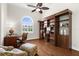 Home office features a ceiling fan, hardwood floors, a built-in bookcase and a window for natural light at 186 Portofino Dr, Nokomis, FL 34275