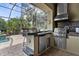 Outdoor kitchen featuring modern stainless steel appliances, a sink, and ample counter space for cooking at 186 Portofino Dr, Nokomis, FL 34275